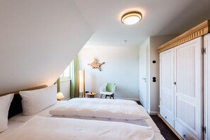 Ein Schlafzimmer mit einem Bett, einem Sessel, einem Kleiderschrank und einer sternförmigen Wanddekoration.