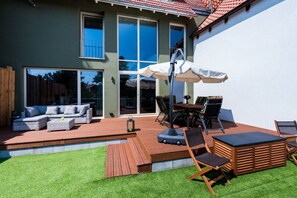 A modern house with a deck, outdoor furniture, and a large window. - To the cheerful day laborer (Quedlinburg)