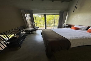 A hotel room with a bed, a small table, a chair, and a balcony with a view. - Niira Mirissa (Mirissa)
