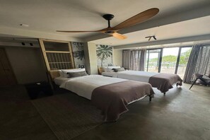 A hotel room with two beds, a ceiling fan, a wardrobe, and a view of the outdoors. - Niira Mirissa (Mirissa)