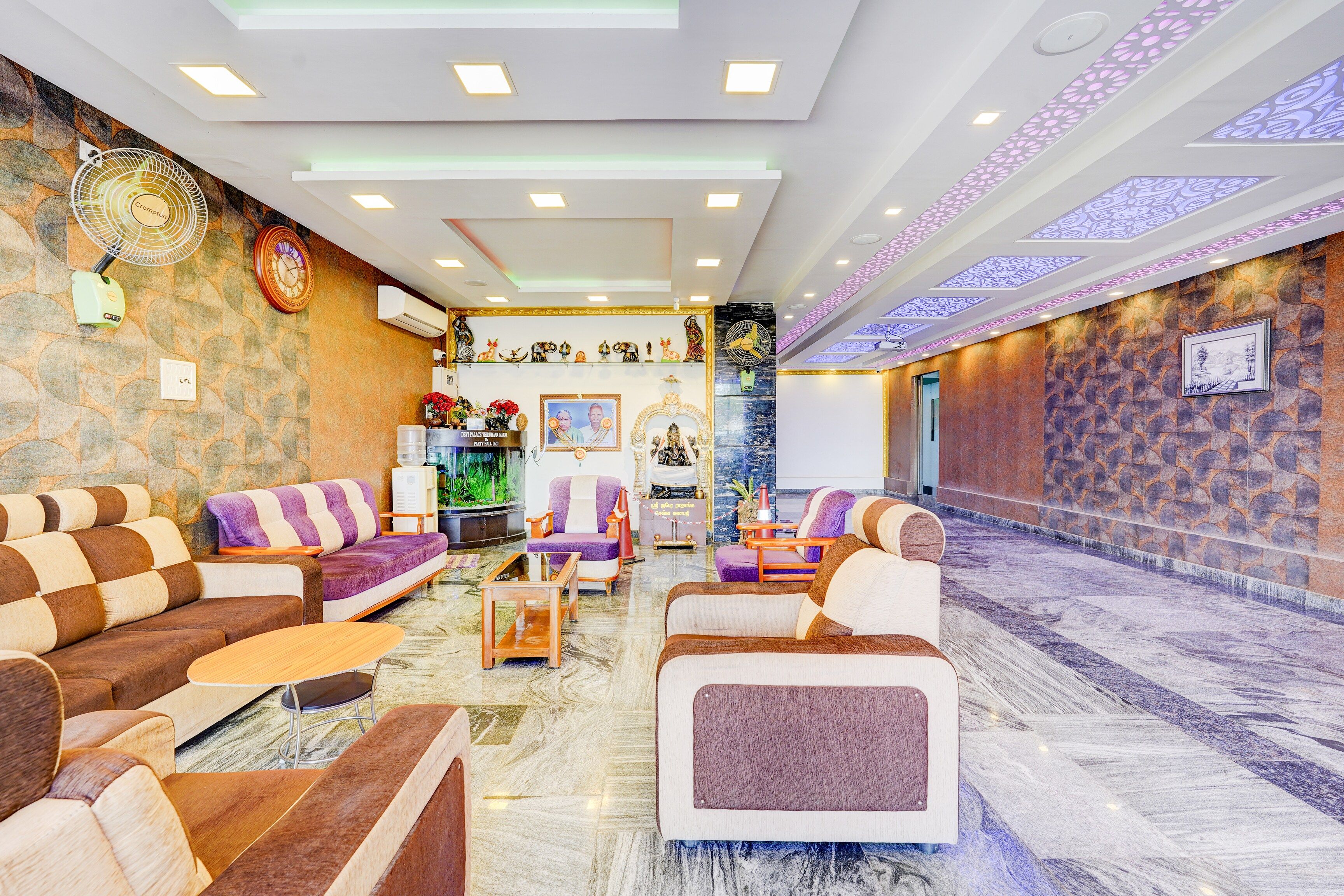 Una hall d'albergo con zone relax, una reception e una parete decorativa con manufatti culturali.
