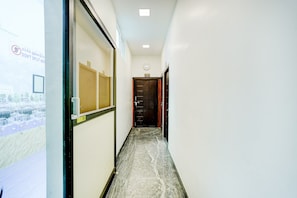Un pasillo con vistas a un paisaje urbano a través de una ventana, una puerta con la etiqueta '303 VIP' y un letrero que dice 'NO SEPARAR AQUÍ'.