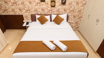 A hotel room with a bed, a nightstand, a telephone, and a wardrobe.