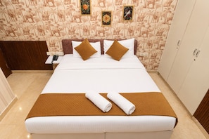 Una habitación de hotel con cama, mesita de noche, teléfono y armario.