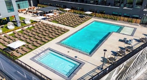 A rooftop pool area with multiple swimming pools and lounge chairs. - Landing Stunning 1bd, Gym, Pool (Nashville)
