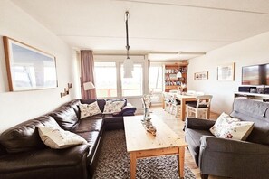 A living room with a sofa, a coffee table, and a television. - Holiday apartment Strandläufer 37 Ameland (Buren\/Ameland)