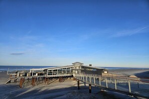 A beachside pier with a viewing platform and a building labeled 'Strandhuyis.' - Holiday apartment with 1 bedroom (Buren\/Ameland)