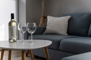 A bottle of Auszaz white wine and two glasses on a white round table. - Holiday apartment in Büsum with swimming pool (Büsum)