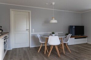 A modern kitchen with a dining area, a television, and a door. - Holiday apartment in Büsum with swimming pool (Büsum)