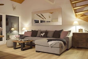 A cozy living room with a sofa, coffee table, and lamps. - Holiday apartment with 1 bedroom (Braunlage)