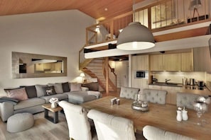 A modern interior with a dining area, sofa set, and a staircase leading to an upper level. - Holiday apartment with 1 bedroom (Braunlage)