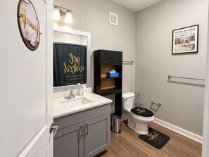 A modern bathroom with a toilet, sink, and vanity.