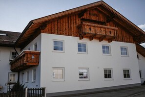 Ein mehrstöckiges Gebäude mit weißer Fassade und hölzernen Balkonen.