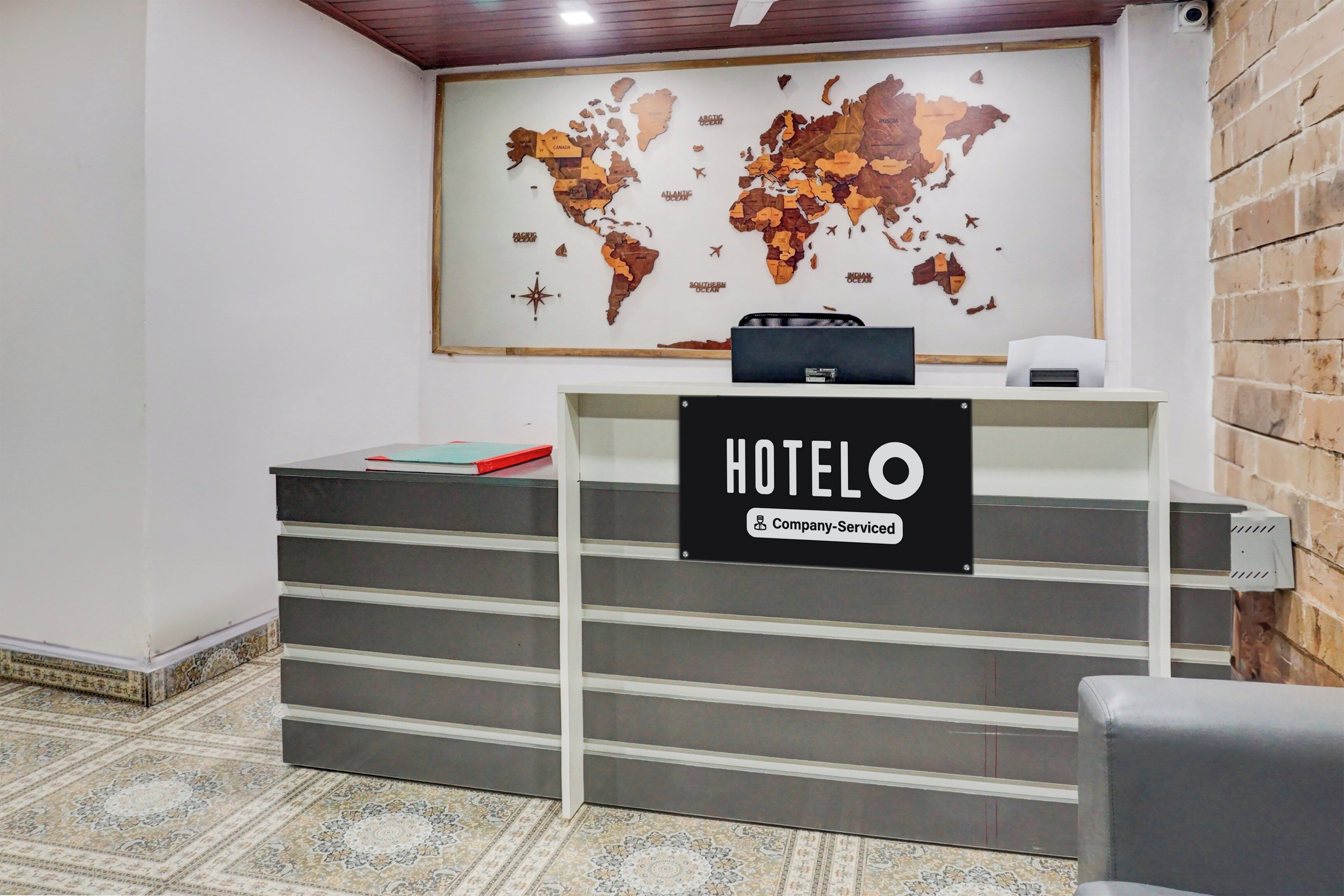A reception desk with a world map and a sign that reads 'HOTEL'.
