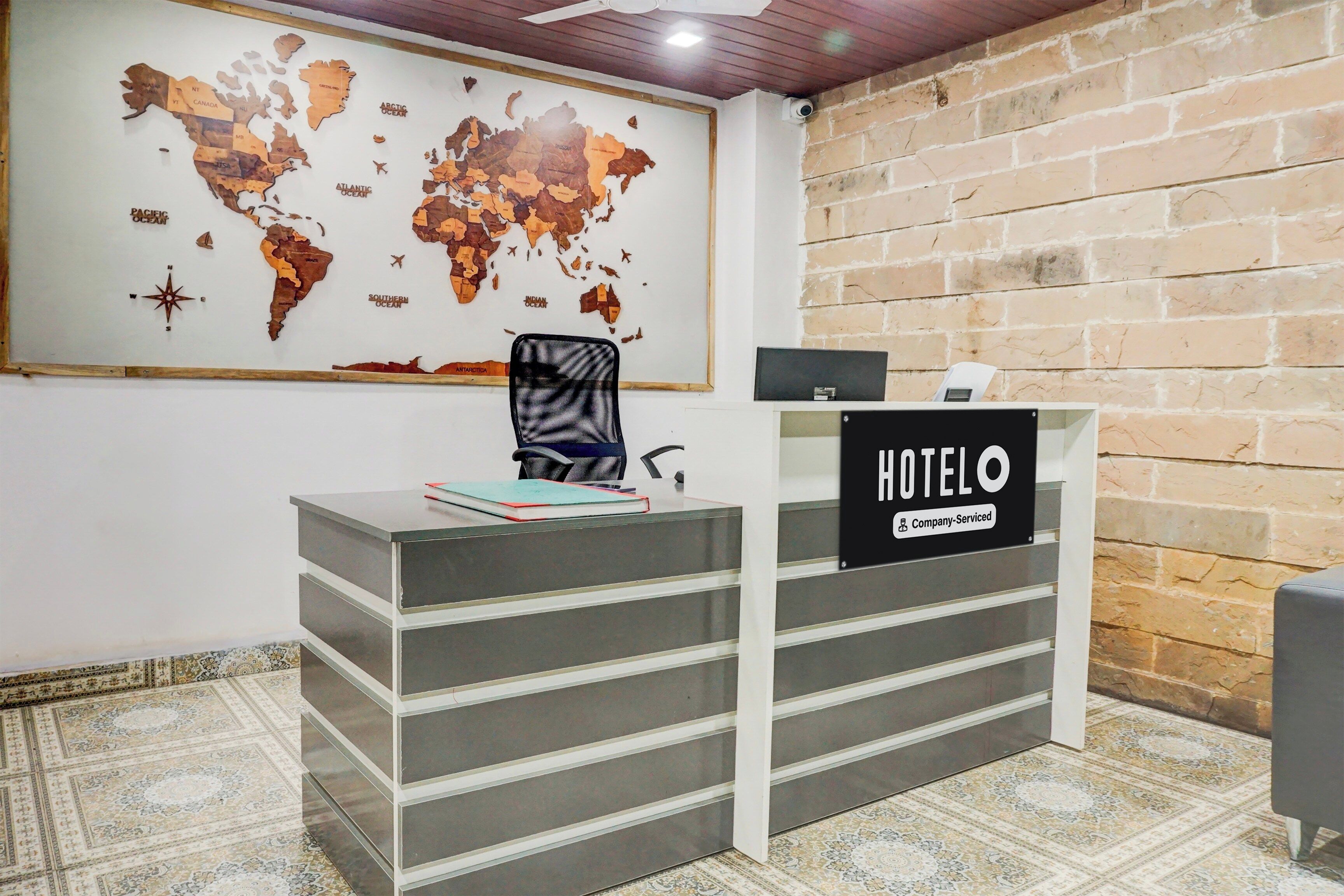 Una recepción con un mapa mundial y un cartel que dice 'HOTEL'.