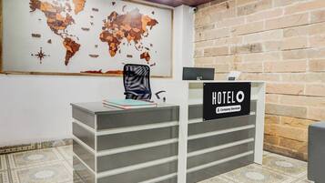 Una recepción con un mapa mundial y un cartel que dice 'HOTEL'.