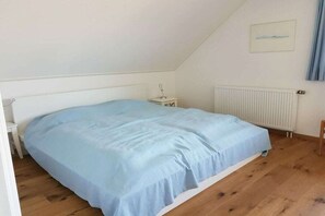 A bedroom with a single bed, a nightstand, a radiator, and a picture on the wall. - Holiday home in Buren with swimming pool (Buren)