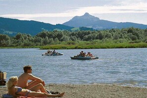 A lake with boats and people, surrounded by hills. - Holiday apartment in Wertach with Wi-Fi (Wertach)