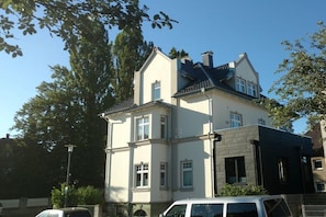 A two-story house with a prominent gabled roof, a visible chimney, and a window with a shutter. - Holiday apartment with 2 bedrooms (Detmold)