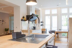 A modern kitchen with a central island, stainless steel appliances, and a large window providing natural light. - Holiday apartment with 2 bedrooms (Detmold)