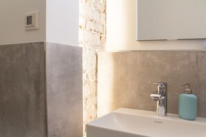 A bathroom with a white sink, a chrome faucet, and a blue soap dispenser. - Holiday apartment with 2 bedrooms (Detmold)