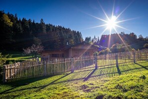 A rural property with a wooden fence, a house, and a field. - Alpenchalet Sachrang (Aschau im Chiemgau \/ Sachrang)