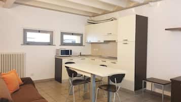 Una cocina funcional con comedor, un sofá y una pequeña mesa.