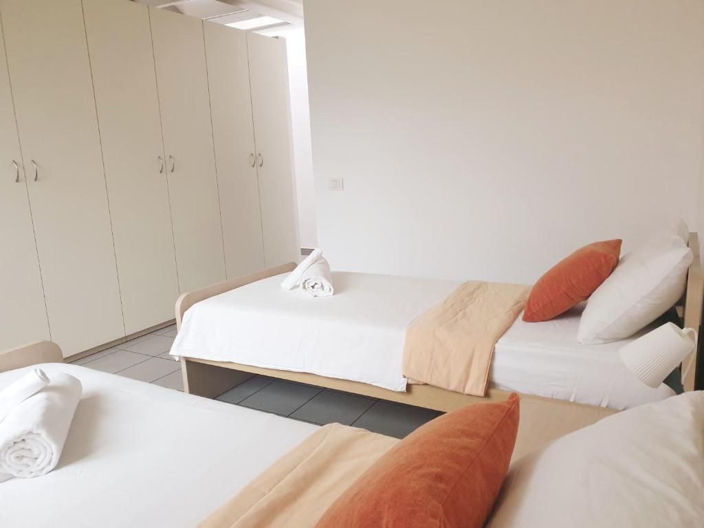 Una habitación de hotel con dos camas, un armario y baño.