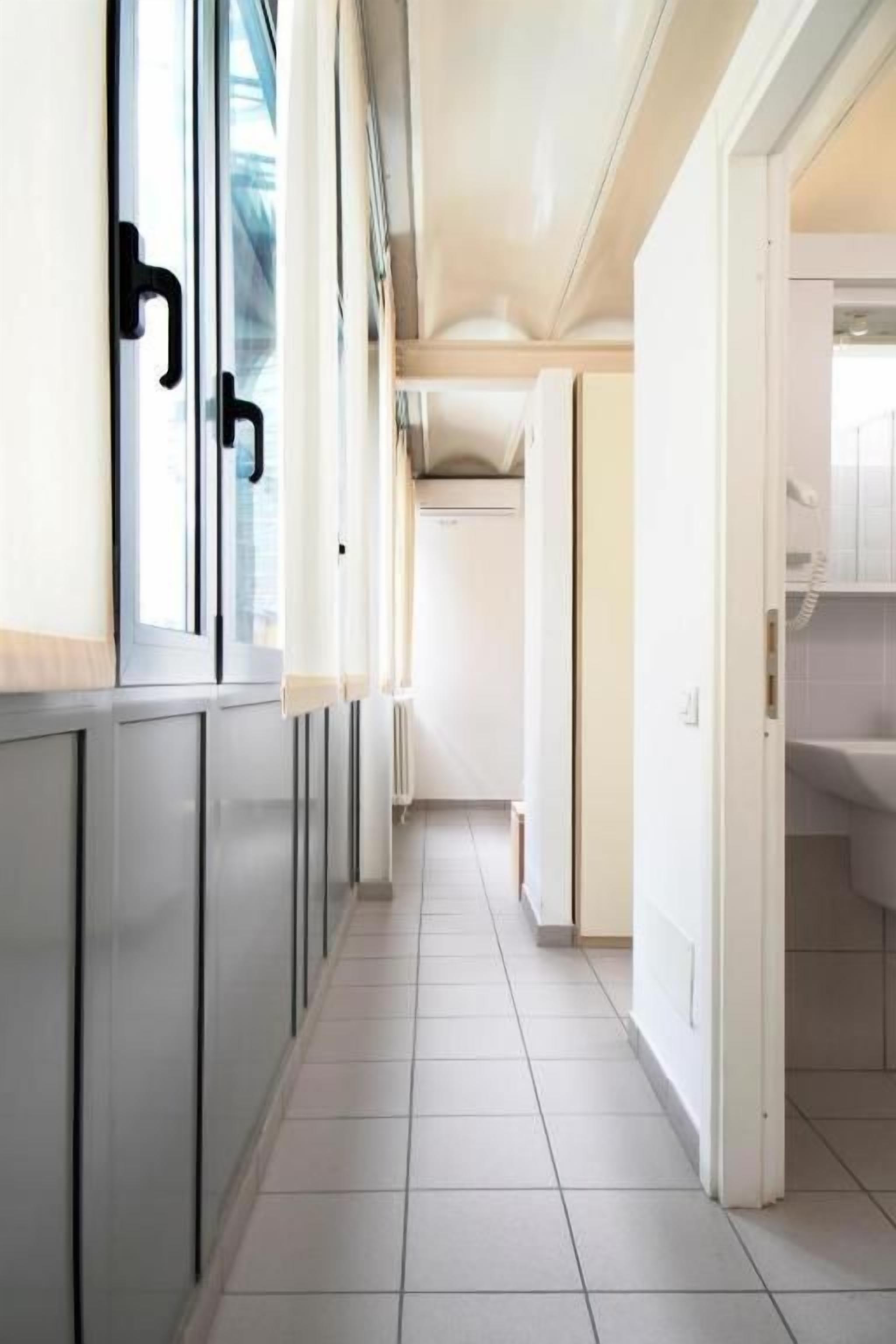A narrow hallway with a kitchen area on one side and a bathroom on the other.