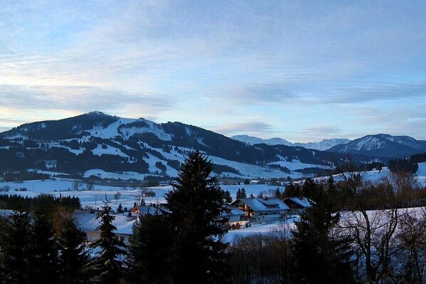A mountainous landscape with snow-covered peaks and a small settlement with houses. - Holiday apartment with 1 bedroom (Oy-Mittelberg)
