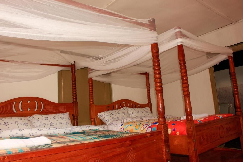 Una cama con dosel, cabecera de madera y colcha con estampado floral.