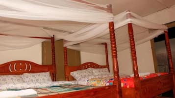 Una cama con dosel, cabecera de madera y colcha con estampado floral.