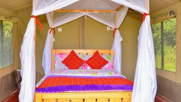 Una cama con dosel, cabecera de madera y colcha colorida.