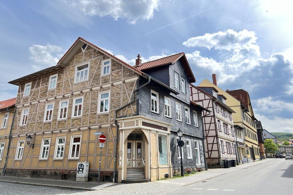 A row of traditional European buildings with a cobblestone street and a clear sky.