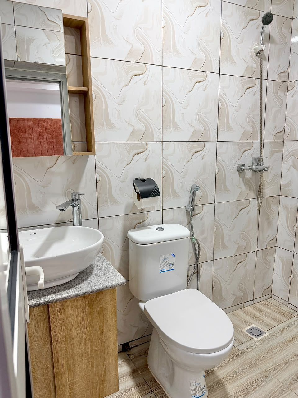 A bathroom with a white sink, toilet, and shower.
