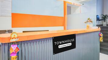 A reception desk with a sign reading 'TOWNHOUSE Company-Serviced'.