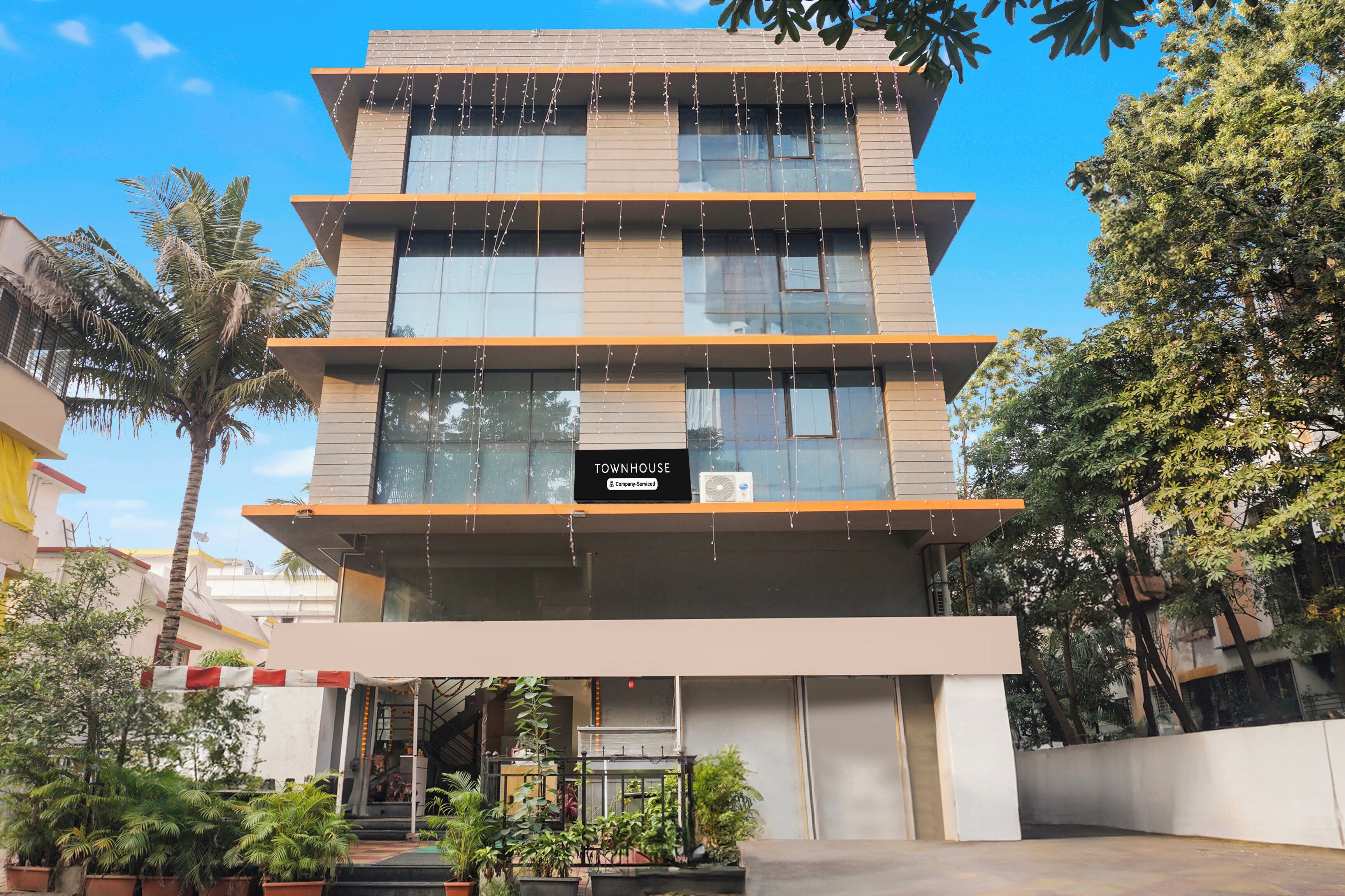 A multi-story building with a sign reading 'TOWNHOUSE Company-Serviced'.