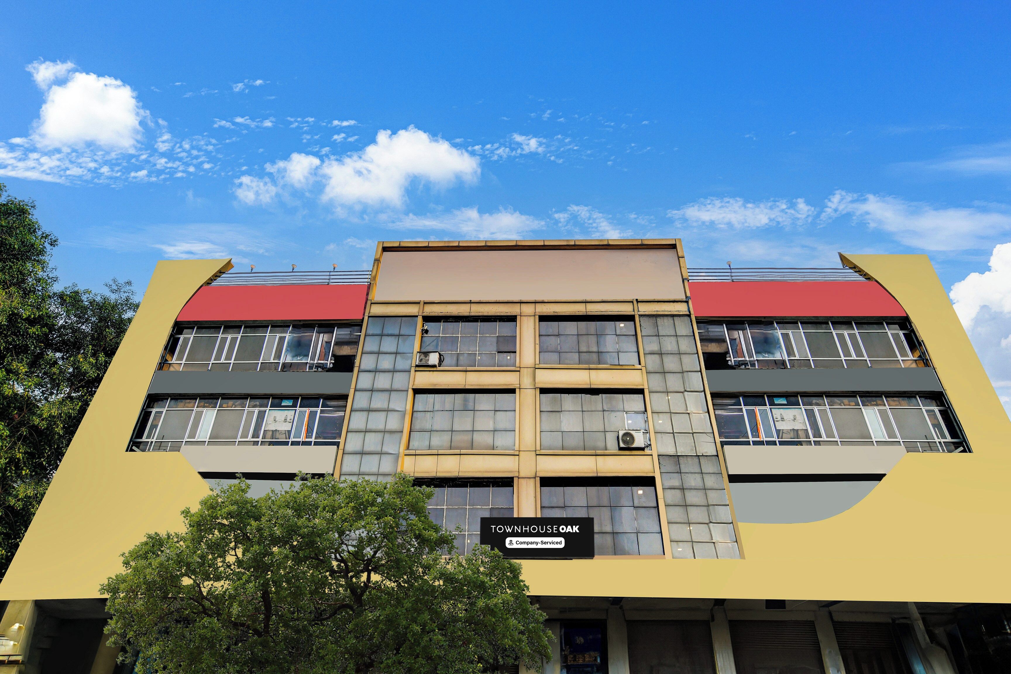 A multi-story building with a sign reading 'TOWNHOUSE OAK' and a company-serviced label.