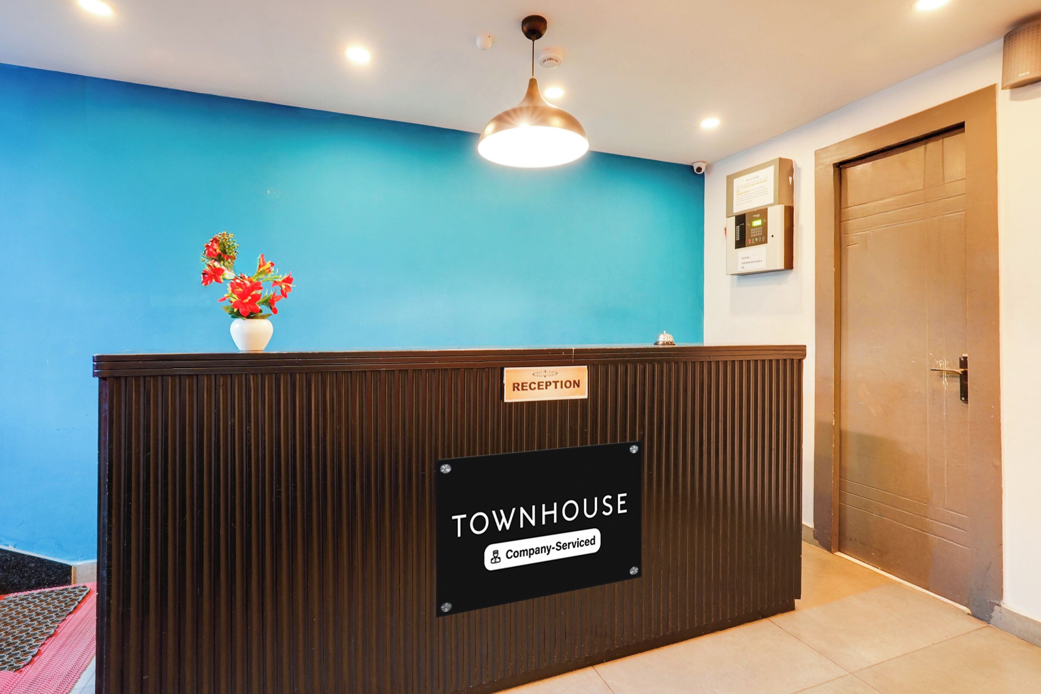 Una recepción con un cartel que dice 'RECEPTION' y un cartel de 'TOURNHOUSE Company-Serviced'.