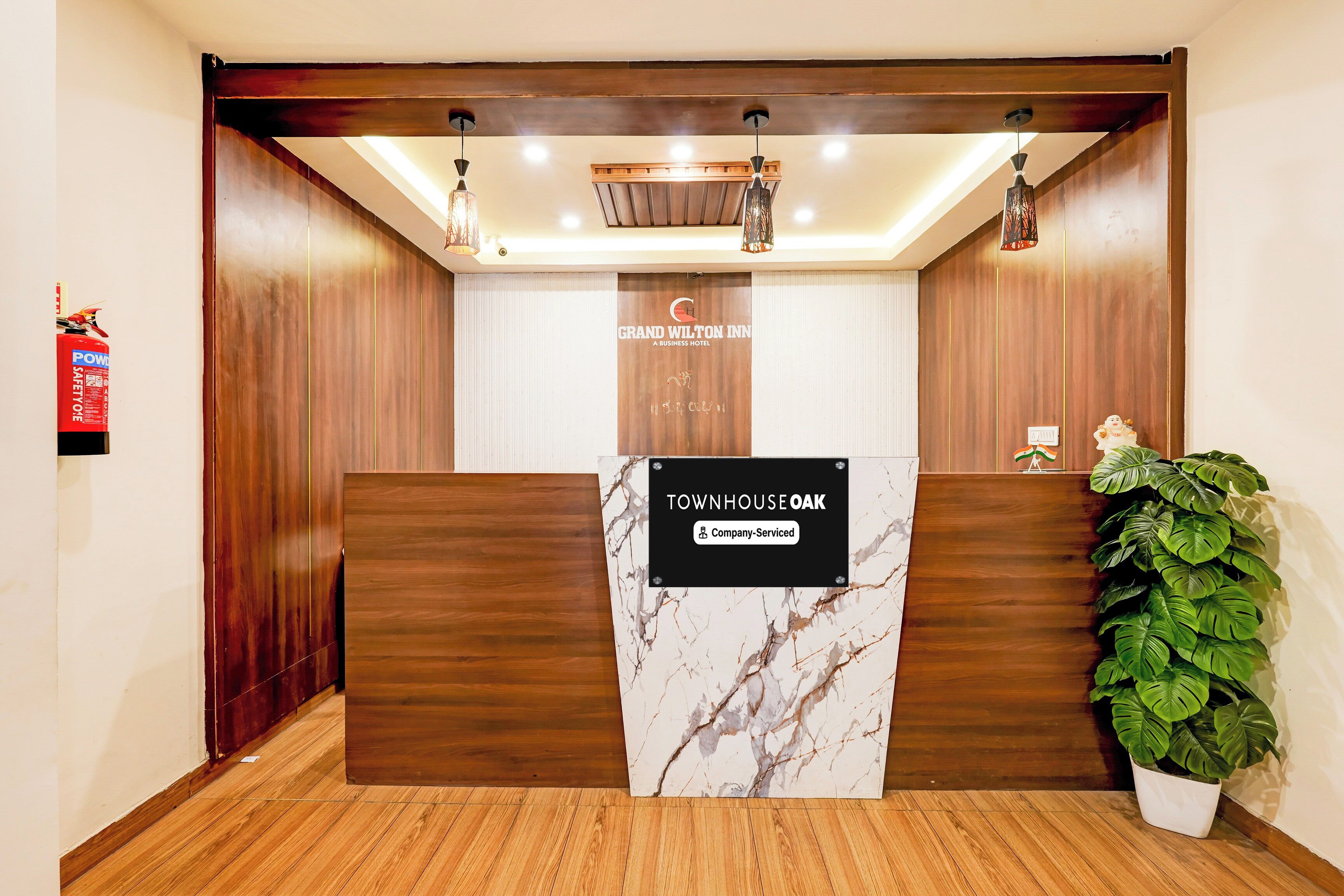 A reception desk with a marble top, wooden paneling, and a sign indicating it is company-serviced.