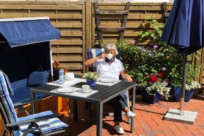 An outdoor seating area with a table, chairs, and a covered table. - Föh's little house || Kappeln Stadt (Kappeln Stadt)