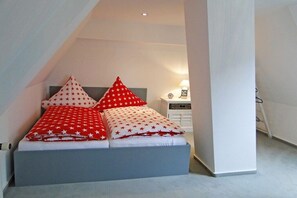 A bedroom with a bed, pillows, a nightstand, and a lamp. - Föh's little house || Kappeln Stadt (Kappeln Stadt)