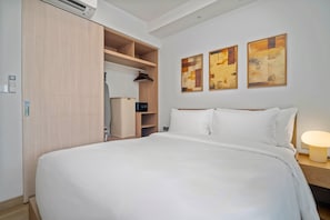 A hotel room with a large bed, a wardrobe, a hanging closet, and two abstract paintings on the wall. - Skypark Celeste 6, One-bedroom 6108 1Bx Ground Floor (Choeng Thale)