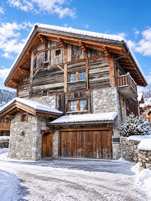 A multi-story wooden chalet with stone foundations, a wooden balcony, and a snow-covered roof. - New Listing (Les Allues)