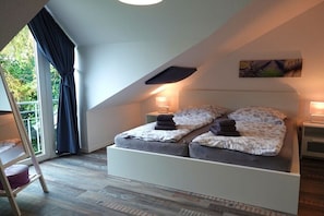 A bedroom with a bed, bedside lamps, a window with curtains, and a view of greenery outside. - Holiday home with 2 bedrooms (Kappeln Kopperby)