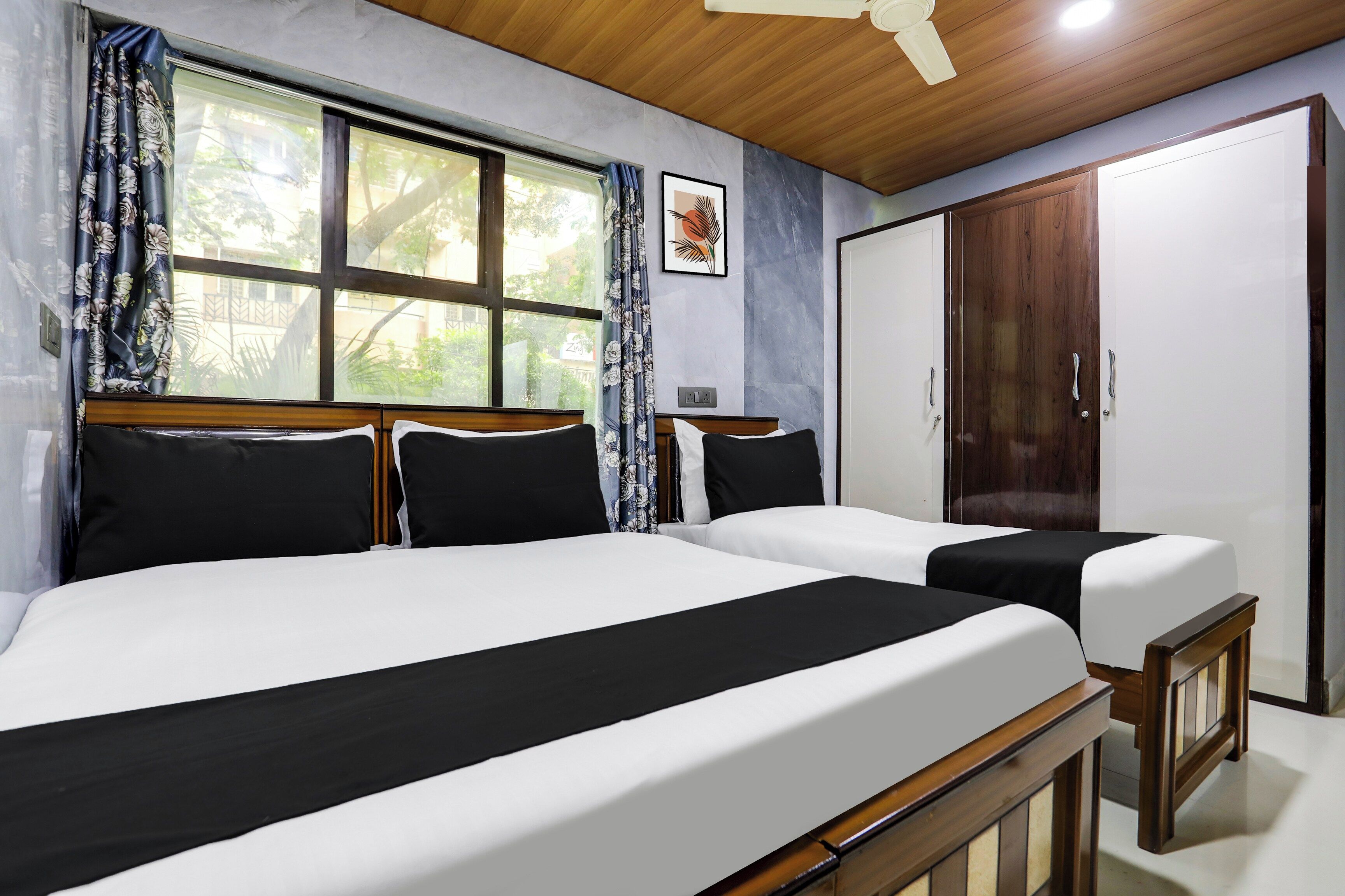 Una habitación con dos camas, un armario y una ventana con cortinas.
