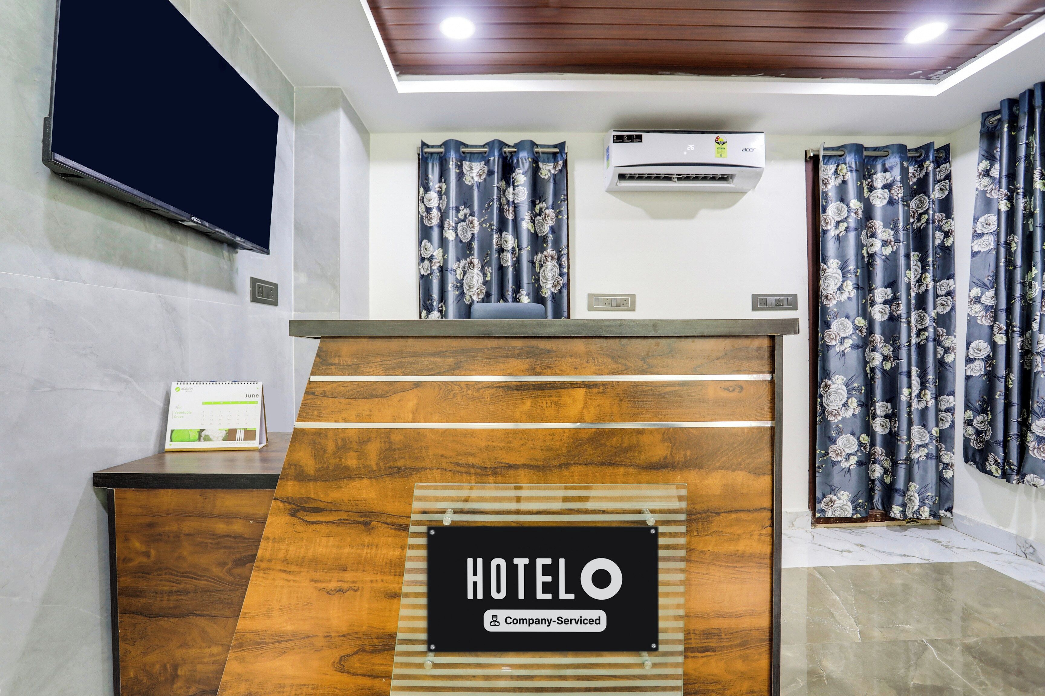 Una recepción de hotel con un cartel que dice 'HOTEL', un calendario y una unidad de aire acondicionado encima.