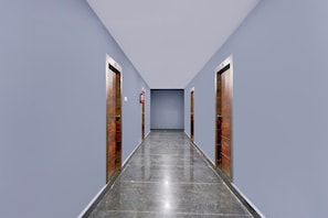 A long, narrow hallway with a polished floor, flanked by doors on both sides. - Townhouse Kukatpally (Hyderabad)