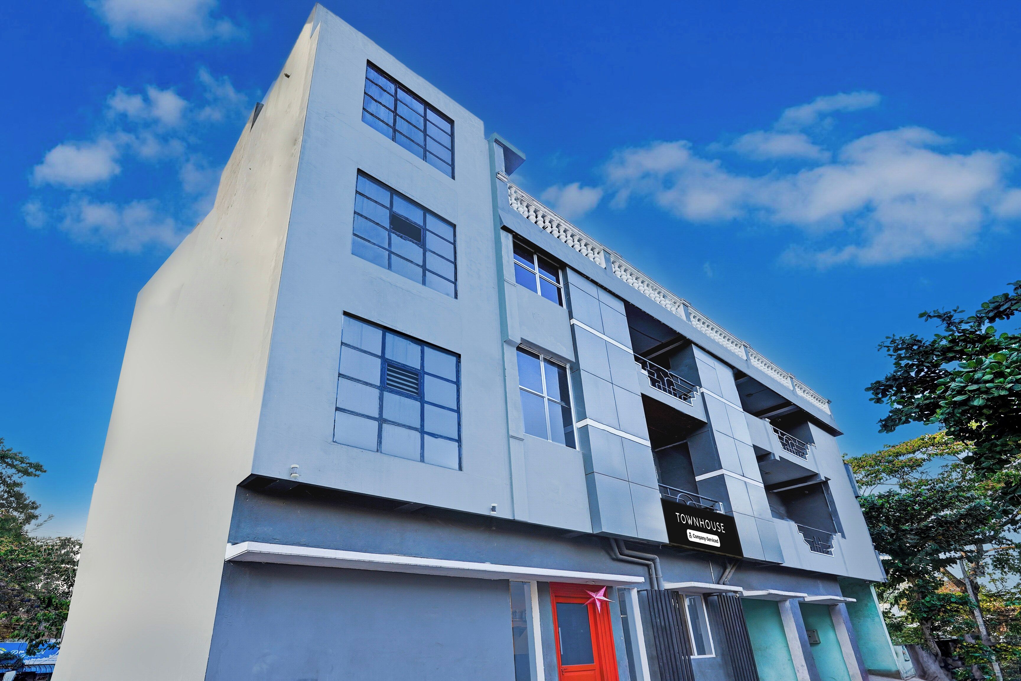 A multi-story building with a prominent 'TOWNHOUSE' sign, large windows, and a red door.