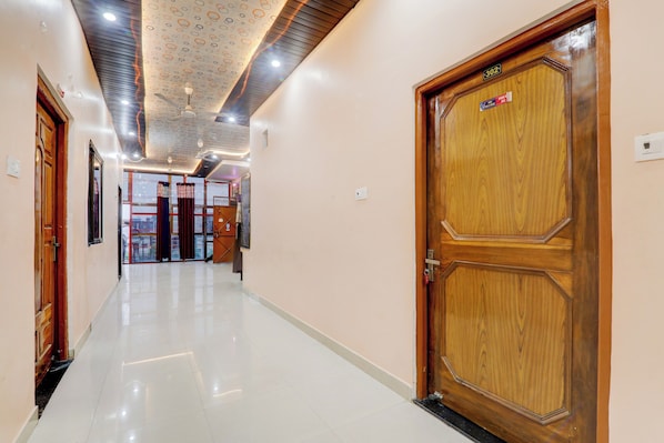 A hotel corridor with a wooden door labeled '302' and a ceiling with a circular pattern. - Hotel O Saryu Ghat (Ayodhya)